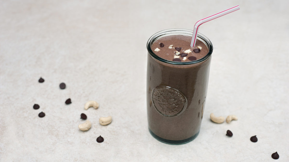 a chocolate smoothie in a glass with a straw